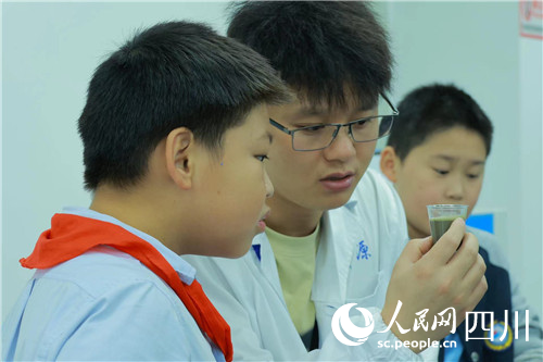 专家带领孩子们做实验。人民网记者 李平摄